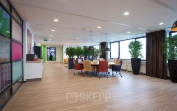 Kantoorruimte huren op Europalaan 24, Maastricht-Airport met moderne inrichting, veel planten, grote ramen en ruime vergadertafels.