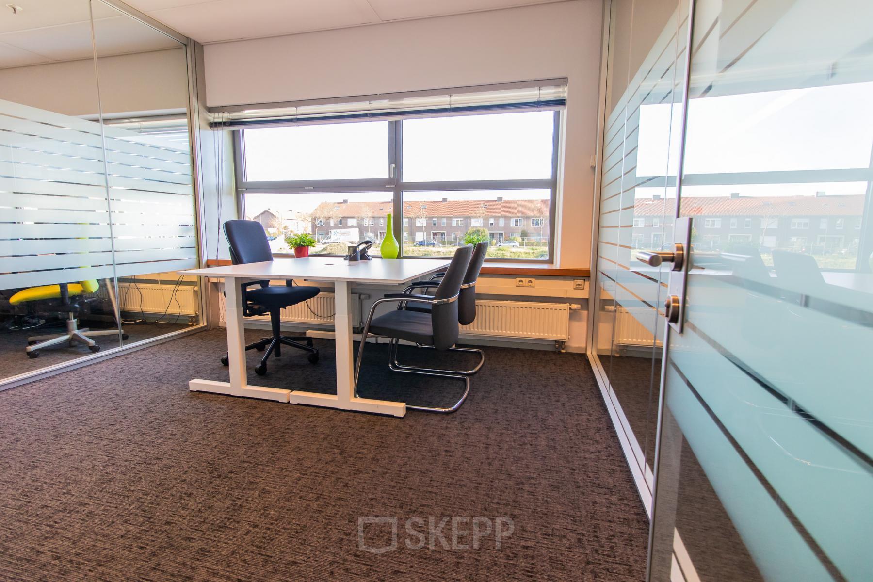 Licht kantoor op Avenue Ceramique 221 in Maastricht met glaswanden, twee bureaus en comfortabele stoelen. Ideaal voor kantoorruimte huren en productief werken.