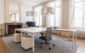 Lichte kantoorruimte huren aan Markt 14 in Maastricht met grote ramen, moderne bureau-opstelling en minimalistisch design in het kantoorpand.