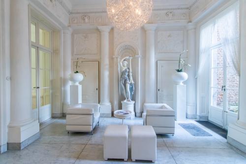 Elegante kantoorruimte met klassieke beeldhouwkunst en moderne witte meubels op Markt 14, Maastricht, ideaal voor wie kantoorruimte wil huren in een historisch kantoorpand.