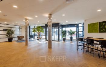 Moderne kantoorruimte in Meppel met grote ramen, veel natuurlijk licht en stijlvolle zitjes. Ideaal om kantoorruimte te huren voor een professionele werkomgeving met een frisse uitstraling.