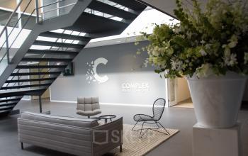 Moderne ontvangstruimte van het kantoorpand op Rijksweg 79 in Naarden met zitjes en planten.