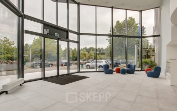 Modern kantoorpand op Nevelgaarde 8-35 in Nieuwegein met glazen entree en stijlvolle, kleurrijke zitplaatsen. Voorzien van grote ramen die veel daglicht binnenlaten, ideaal voor bedrijven die kantoorruimte willen huren.