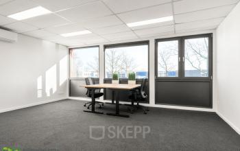Lichte kantoorruimte met een tafel en twee stoelen aan de Nijverheidsweg 9B in Nieuwegein, beschikbaar voor verhuur.