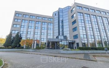 Modern kantoorpand aan Nevelgaarde 8-19 in Nieuwegein, te huur. Strakke glazen gevels en entree met hoge ramen. Ideaal voor bedrijven die een representatieve kantoorruimte zoeken.