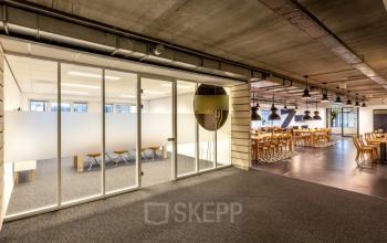 Kantoorruimte huren in het moderne kantoorpand gelegen aan Zoomstede 13-25, Nieuwegein. Open gemeubileerde werkruimte met vergaderzalen zichtbaar door glazen wanden.