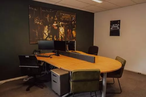 Gemeubileerde kantoorruimte met een grote houten tafel, bureaustoelen en twee beeldschermen, gelegen op Abdis van Thornstraat 74 in Oosterhout Nb.