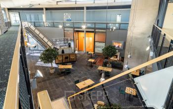 Overzicht van ruime kantoorpand met open indeling, moderne inrichting en centrale trap in Oosterwolde. Ideaal voor kantoorruimte huren.