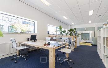 Kantoorruimte huren in Reeuwijk met moderne werkplekken en veel natuurlijk licht, gelegen aan de Leeghwaterstraat 25. Het interieur biedt een uitnodigende sfeer met groene accenten.