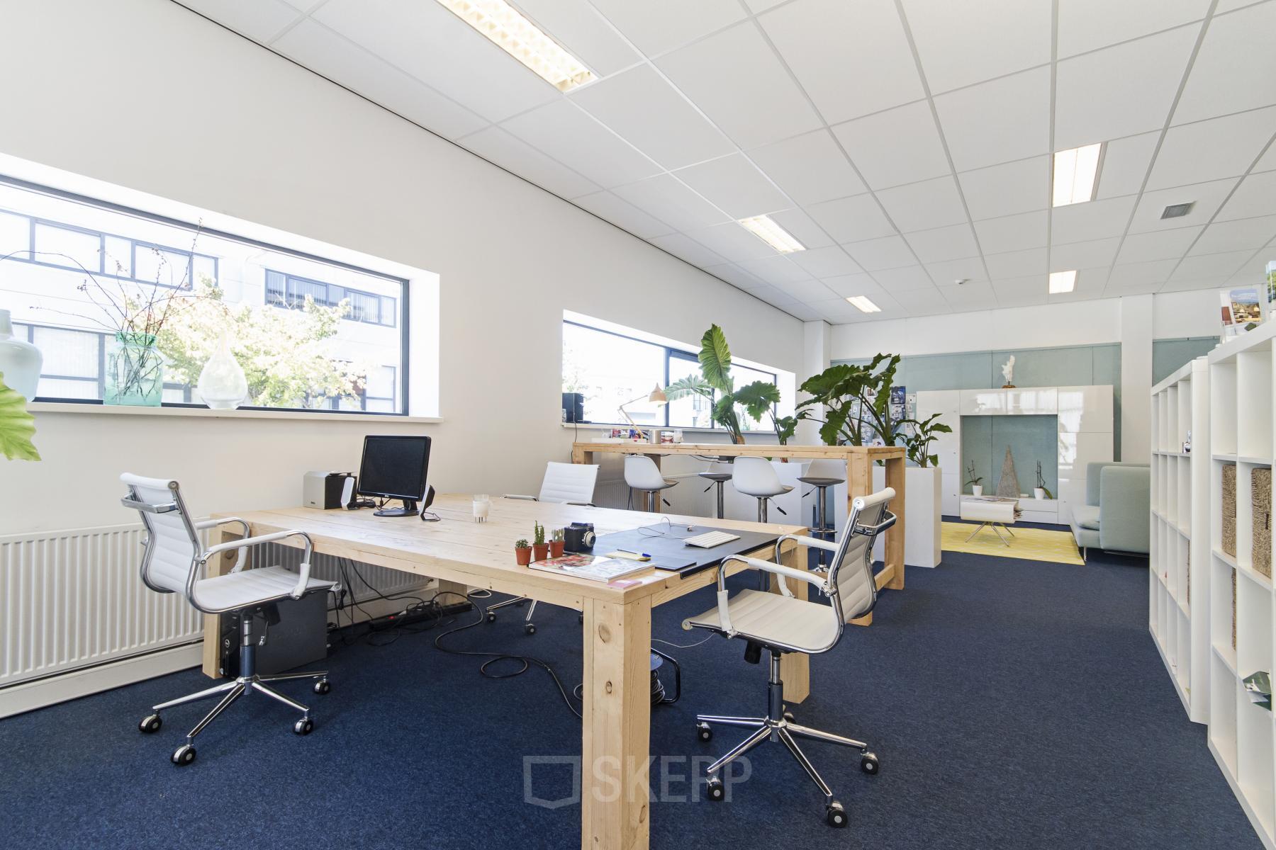 Kantoorruimte huren in Reeuwijk met moderne werkplekken en veel natuurlijk licht, gelegen aan de Leeghwaterstraat 25. Het interieur biedt een uitnodigende sfeer met groene accenten.