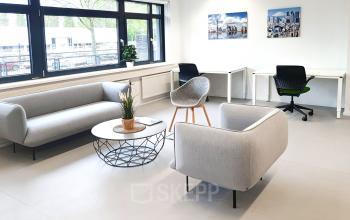 Moderne kantoorruimte met grote ramen, voorzien van comfortabele zithoek en bureaus, ideaal voor werk of overleg. Gelegen op Einsteinlaan 28 in Rijswijk, geschikt voor kantoorruimte huren.