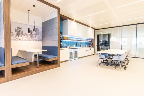 Moderne kantoorruimte huren in een stijlvol ingericht kantoorpand op Einsteinlaan 28, Rijswijk. Heldere open werkvloer met vergadertafel, pantry en ingebouwde zithoeken.
