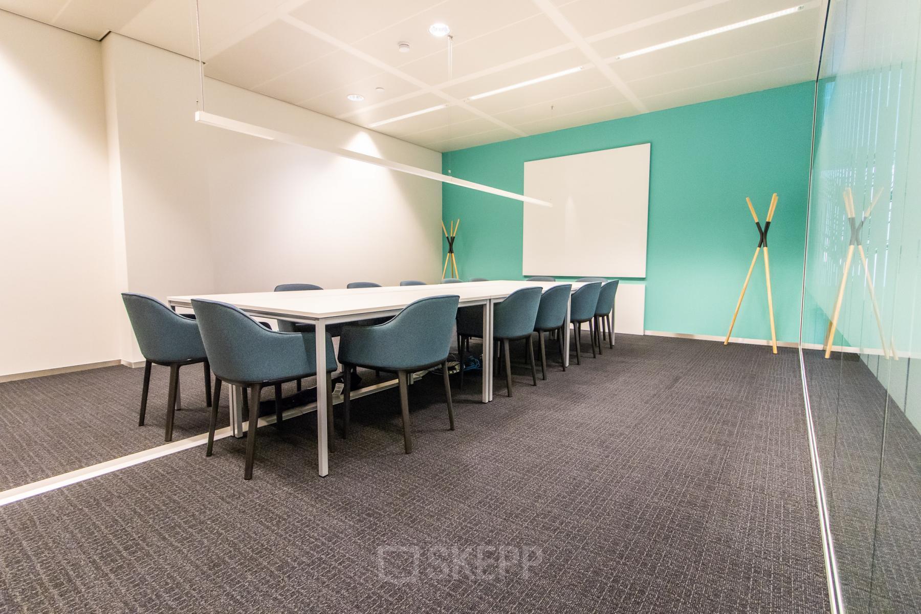 Vergaderruimte in kantoorpand op Einsteinlaan 28, Rijswijk, met grote vergadertafel en stoelen, geschikt voor kantoorruimte huren.