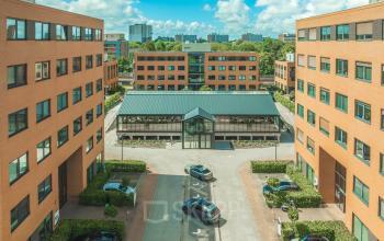 Kantoorpand aan Lange Kleiweg 50-62 in Rijswijk, omgeven door meerdere bakstenen gebouwen met parkeerplaatsen. Ideaal voor bedrijven die kantoorruimte willen huren in een zakelijk en toegankelijk gebied.