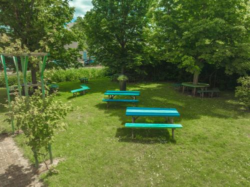 Buitenruimte met groene grasvelden en meerdere picknicktafels in het kantoorpand op Lange Kleiweg 50-62, Rijswijk.