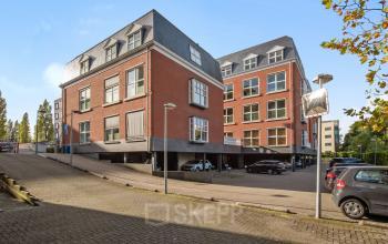 Exterieur van kantoorpand aan Laan van Vredenoord 17-19 in Rijswijk, met rode gevel en meerdere ramen, parkeergelegenheid aan de zijkant.