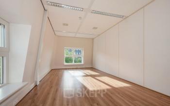 Lichte kantoorruimte aan Laan van Vredenoord 17-19 in Rijswijk met grote ramen en houten vloer, ideaal voor kantoorruimte huren.