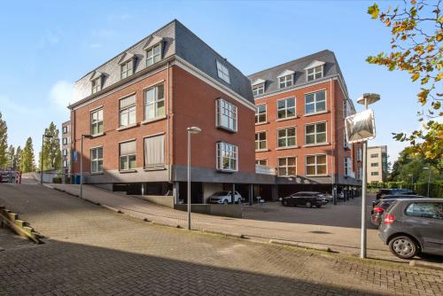 Exterieur van kantoorpand aan Laan van Vredenoord 17-19 in Rijswijk, met rode gevel en meerdere ramen, parkeergelegenheid aan de zijkant.