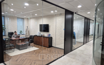 Stijlvolle kantoorruimte op Laan van Zuid Hoorn 70 in Rijswijk met glazen wanden, moderne meubels en een werknemer in gesprek.