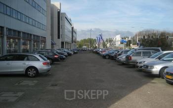 Buitenzijde van kantoorpand Patrijsweg 4-140 in Rijswijk, met parkeerplaatsen en geparkeerde auto's zichtbaar.