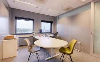 Kantoorruimte te huur in Rijswijk, Patrijsweg 4-140, met vergadertafel, stoelen en bureaus naast ramen met uitzicht.