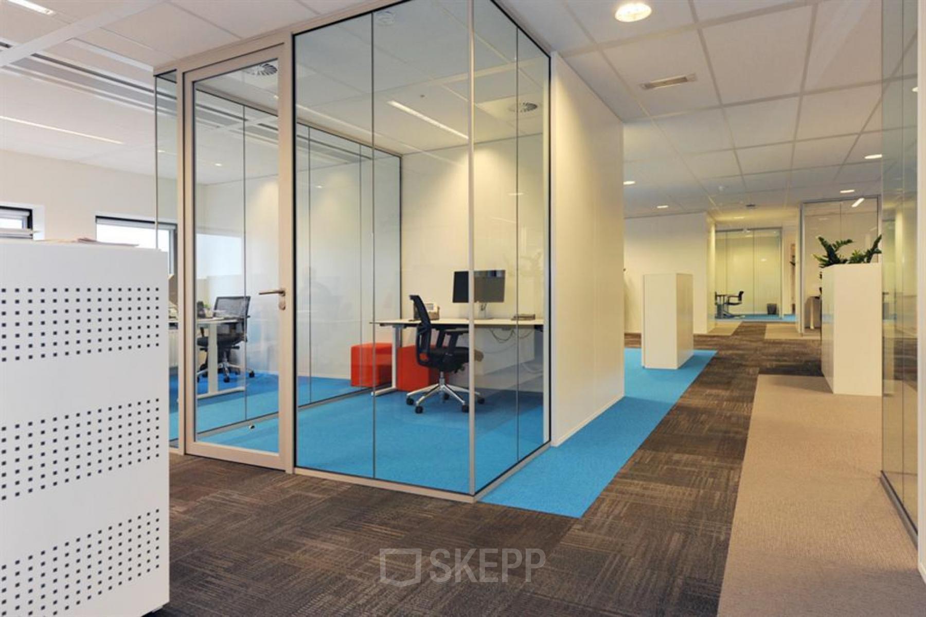 Kantoorruimte huren op Patrijsweg 4-140 in Rijswijk met glazen wanden, blauwe vloerbedekking en moderne werkplekken.