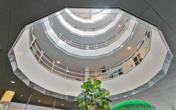 Binnenzijde van het moderne kantoorpand op Kapellerpoort 1 in Roermond met meerdere verdiepingen en veel lichtinval.