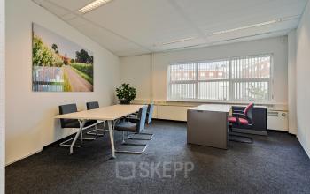 Zakelijk ingerichte kantoorruimte met drie bureaus en stoelen op Kapellerpoort 1, Roermond.