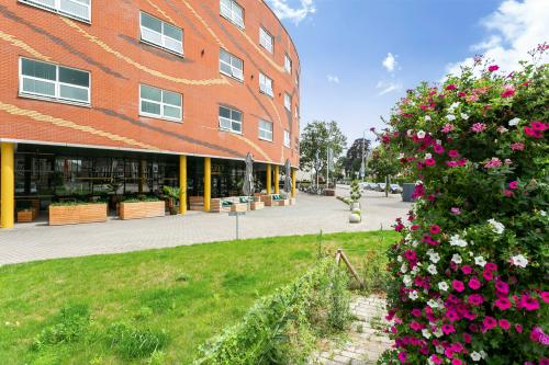 Buitenaanzicht van het kantoorpand aan Kapellerpoort 1 in Roermond, met modern baksteenontwerp en groene omgeving.