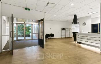 Ingang van een modern kantoorpand op Noordhoven 2, Roermond, met een lichte entree en een stijlvolle ontvangstbalie. Ideaal voor het huren van praktische kantoorruimte.