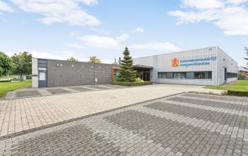 Exterieur van het kantoorpand op Noordhoven 2, Roermond. Moderne grijze gevel met parkeerplaats en groenvoorziening. Geschikt voor kantoorruimte huren.