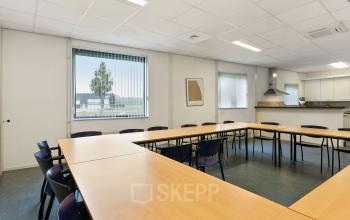 Kantorencomplex Noordhoven 2 in Roermond biedt een open ruimte met vergadertafels, stoelen en ramen met uitzicht. Perfecte kantoorruimte huren voor meetings of bijeenkomsten.