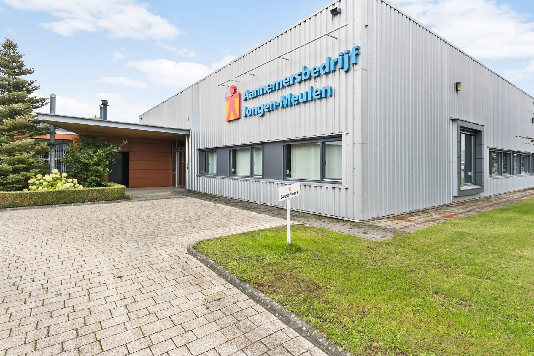 Zakelijk grijs exterieur van kantoorpand op Noordhoven 2, Roermond. Gelegen in een groene omgeving, geschikt voor wie kantoorruimte wil huren.