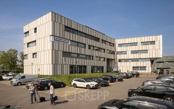 Kantoorpand op Boven de Wolfskuil 3 in Roermond met parkeerplaats en mensen die zakelijke activiteiten uitvoeren. Ideaal voor kantoorruimte huren.