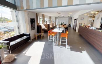 Kantoorruimte te huur in Roermond met moderne inrichting, hoge ramen en een uitnodigende sfeer. Het kantoorpand heeft comfortabele zitplaatsen en een gemeubileerd interieur. Ideaal voor werk of informele bijeenkomsten.