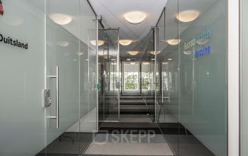 Transparante kantoorgang met glazen wanden in een kantoorpand op Boven de Wolfskuil 3, Roermond. Modern en strak ontwerp biedt mogelijkheden voor kantoorruimte huren.
