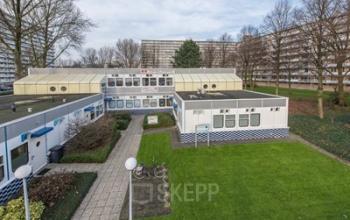 Exterieur van kantoorpand op Marshallweg 7-47 in Rotterdam Alexander, met groen grasveld en omliggende vegetatie.