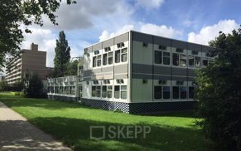 Kantoorpand gelegen op Marshallweg 7-47, Rotterdam Alexander, omgeven door groen gras en bomen, moderne uitstraling.