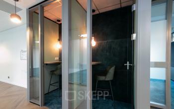 Kantoorruimte aan Prins Alexanderplein 5 in Rotterdam Alexander met moderne werkplekken in afgesloten cabines, perfect voor geconcentreerd werk. Glaswanden zorgen voor een open sfeer en goede lichtinval, ideaal om te huren.