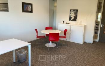 Kantoorruimte huren op Hoofdweg 66 in Rotterdam Alexander met een tafel en stoelen, posters aan de muur, en kasten.