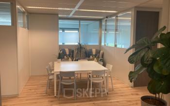 Moderne kantoorruimte huren aan Hoofdweg 66 in Rotterdam Alexander. De ruimte heeft een houten vloer, witte muren, en is voorzien van een grote tafel met stoelen en enkele planten.
