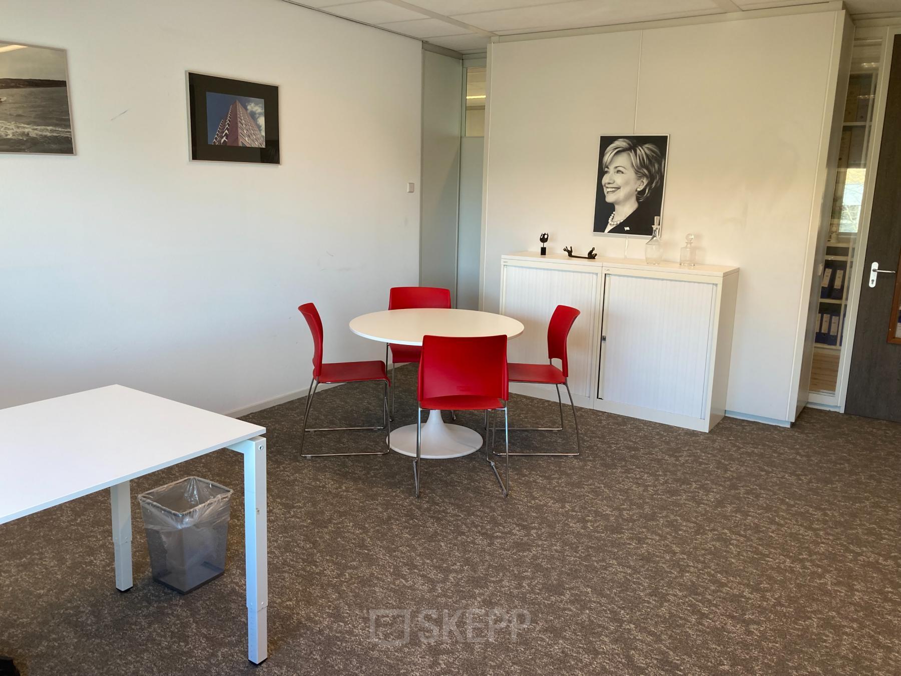 Kantoorruimte huren op Hoofdweg 66 in Rotterdam Alexander met een tafel en stoelen, posters aan de muur, en kasten.