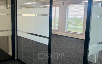 Leeg kantoor in Rotterdam Brainpark met grote ramen en glazen wanden, ideaal voor kantoorruimte huren aan Bahialaan 100.