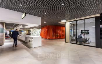 Moderne kantoorruimte aan Weena 505, Rotterdam Centraal Station met ontvangstbalie, glazen vergaderruimte en stijlvolle architectuur.
