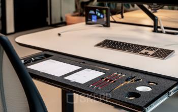 Moderne werkplek in kantoorpand Rotterdam Centraal Station met ergonomische stoel en georganiseerde bureauset voor efficiëntie. Ideale locatie voor het huren van innovatieve kantoorruimte aan Hofplein 19.