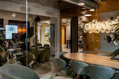 Moderne kantoorruimte huren op Hofplein 19 in Rotterdam Centraal Station met stijlvolle inrichting, inclusief vergaderruimte en comfortabele zitplaatsen. Zakelijke activiteit zichtbaar met mensen in overleg en aan het werk.