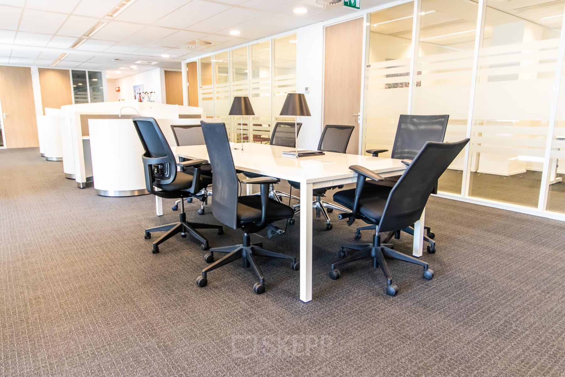 Moderne vergaderruimte huren in kantoorpand op Weena-Zuid 130, Rotterdam Centraal Station met zes comfortabele stoelen en een grote tafel om efficiënt te vergaderen.