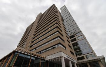 Gezicht op kantoorpand Weena 750 nabij Rotterdam Centraal Station, roodgekleurde gevel met moderne architectuur.
