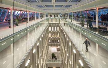 Kantoorruimte huren op Blaak 34, Rotterdam Centrum. Modern kantoorpand met glazen balustrades en een ruim atrium waar volop mensen actief zijn met zakelijke activiteiten.