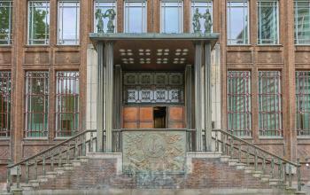 De entree van het kantoorpand aan Blaak 34 in Rotterdam Centrum toont een historische gevel met kunstzinnige elementen, ideaal voor wie kantoorruimte wil huren in een karakteristiek gebouw.